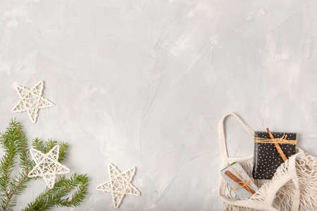 Christmas flat lay with homemade gifts in string bag, fir branches and star decoration with place for textの写真素材