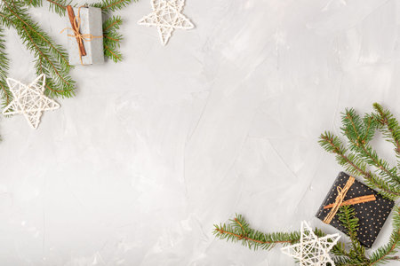 Light Christmas composition with place for text. Fir branches, holiday stars, homemade gifts on a...