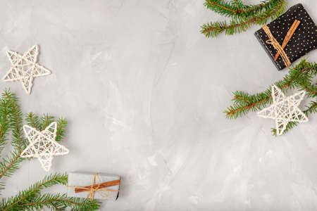 Light Christmas composition with place for text. Fir branches, holiday stars, homemade gifts on a white background. Flat lay, top viewの写真素材