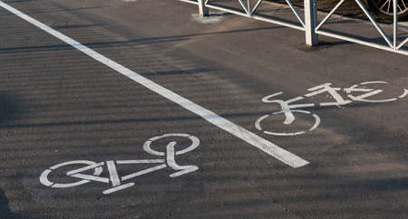 on an asphalt path a bicycle sign in lane direction and the other.の写真素材