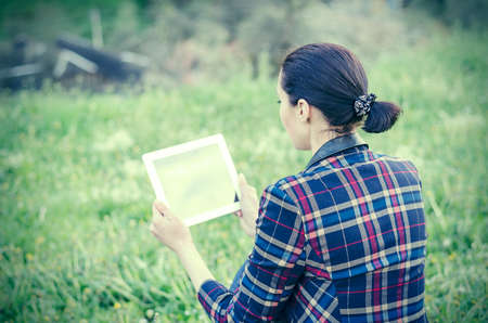 Woman with tablet computer on a background of mountain landscapeの写真素材