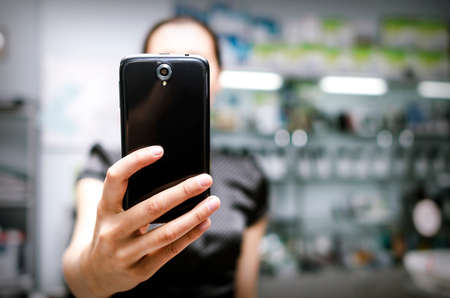 Woman holding a big black smartphone in handの写真素材