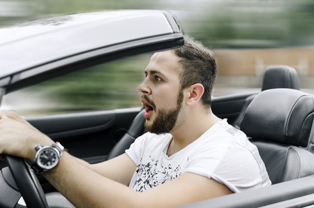 Fright face of man driving car and strongly hold the wheelの写真素材