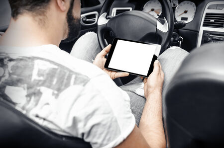 Man in the car, with the Tablet PC in handsの写真素材