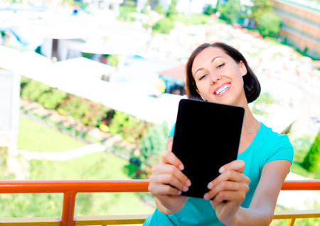 Smiling girl making selfie standing on the balconyの写真素材