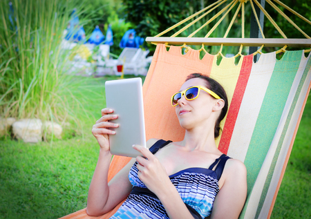 Woman Relaxing In Hammock With Tablet PCの写真素材