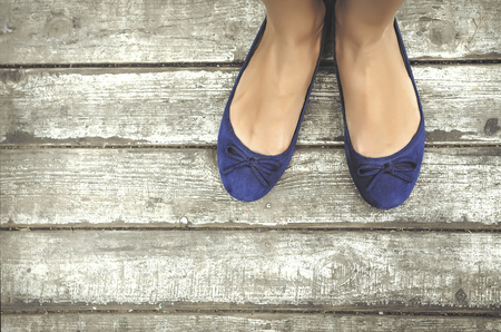 Girls beautiful blue shoes over wooden deckの写真素材