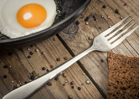 Closeup of fried egg on a cast iron panの写真素材