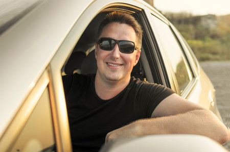 Car driver drive his car in black sunglassesの写真素材