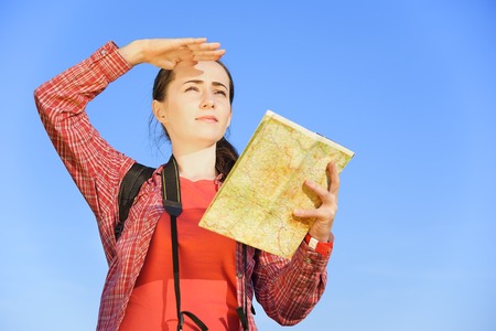 Girl tourist looks into the distance against the blue sky.の写真素材