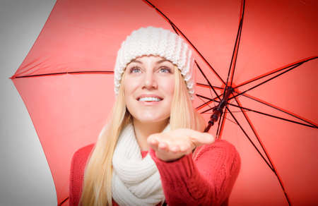 Beautiful blonde with red umbrella isolated on white.の写真素材