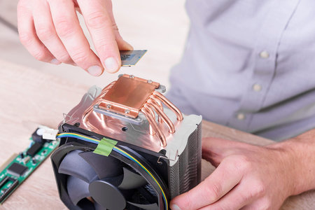 Engineer installing computer processor to big cooler.