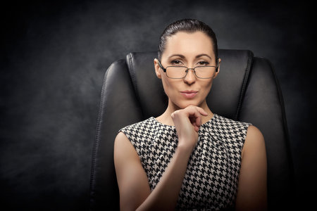 Beautiful business woman  on the black chair.