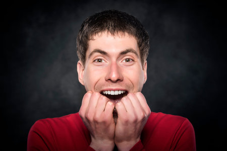 Excited young man on a dark background.の写真素材