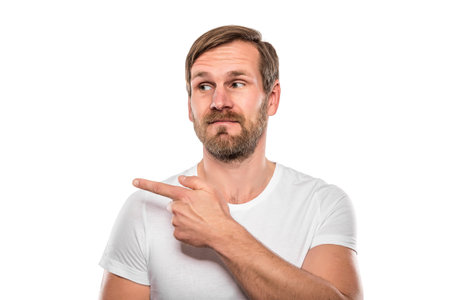Smiling man points to an empty space.. Isolated on white.
