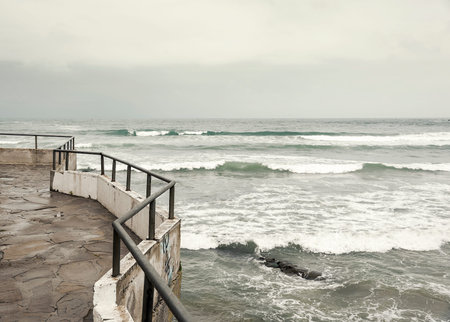 Balcony on a rocky hill above the sea during a storm.の写真素材