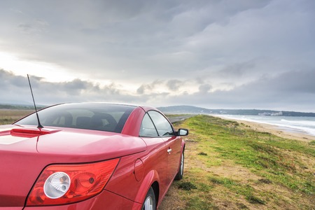 SOZOPOL, BULGARIA - MAY 3: Red car Renault Megane Cabriolet on the wild sand sea beach, on May 3, 2016 in Sozopol, Bulgaria.のeditorial素材