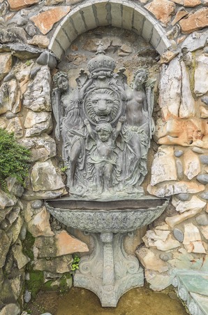 Ancient fountain with statues in the wall.の写真素材