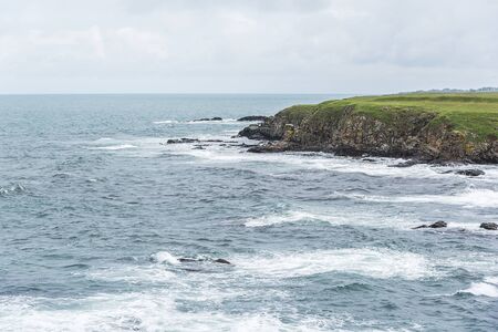A rocky coast and dramatic sea waves.の写真素材