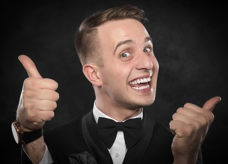 Businessman with Thumb Up over dark background.の写真素材