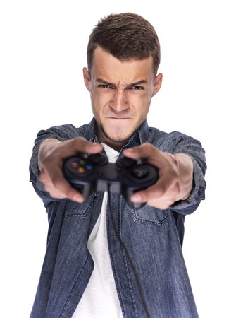 Young man playing on console or computer using a gamepad.の写真素材