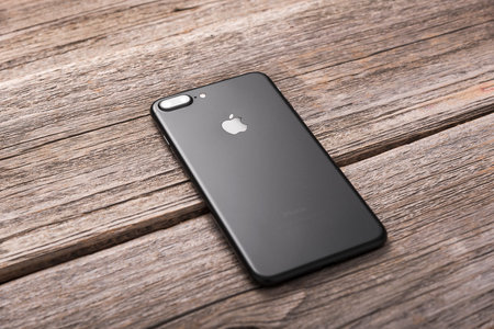 UZHGOROD, UKRAINE - DECEMBER 20, 2016: New black iPhone 7 Plus from the company Apple on a woden...