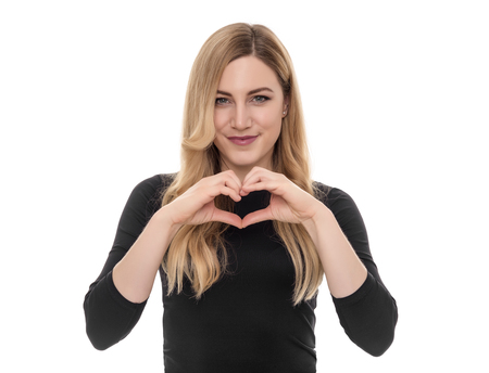 Beautiful blond woman showing heart sign with her hands.の写真素材