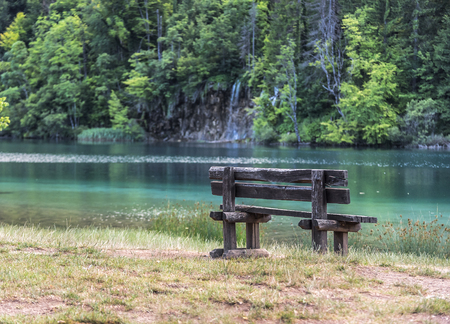 Empty bench on the waterfront with an amazing view of a lake.の写真素材