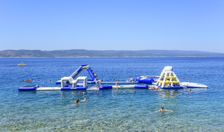 Aquapark on the sea with resting tourists in Brela, Croatia.のeditorial素材