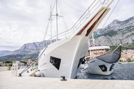Pleasure boat with cheerful tourists enters the port of Makarska, Croatia.のeditorial素材