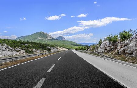 High-speed country road among the mountains on a summer day.の写真素材