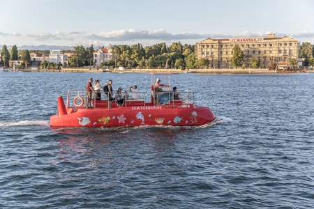ZADAR, CROATIA - JULY 15, 2017: Red walking submarine and tourists on board, on sea waves.のeditorial素材