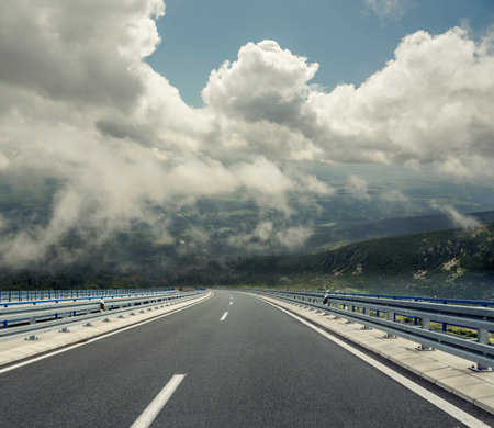 Highway outside the city receding into the highlands. Travel concept. Added a toning filter.