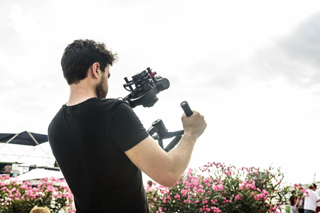 Cameraman shoots video at the camera using a shoulder steadicamのeditorial素材