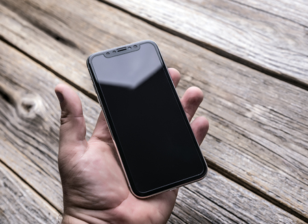 New iPhone X 10 on a wooden background, studio shot.のeditorial素材