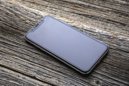 New iPhone X 10 on a wooden background, studio shot.のeditorial素材