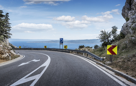 Asphalt road to the sea. Asphalt highway in a sunny day.の写真素材