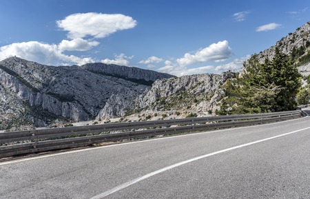 Country road through the rocky mountains and forest.の写真素材