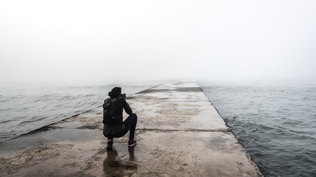 Photographer on a misty pier.の写真素材