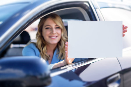 Woman sitting in the car and holding a white blank poster.