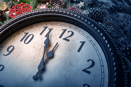 Wall clock in Christmas or New Year decorations are wrapped with fir branches and Christmas decorations. On the clock five minutes to midnight.の写真素材