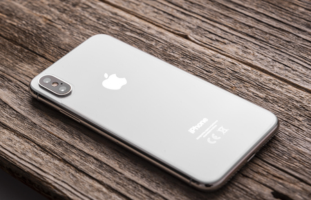 New iPhone X 10 on a wooden background, studio shot.のeditorial素材