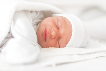 Sleepy baby close-up in a baby cot.の写真素材