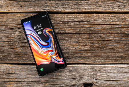 Samsung Galaxy Note 9 smartphone on a wooden background, developed and marketed by Samsung...
