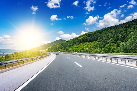 Highway among the mountain scenery in the sun rays.の写真素材