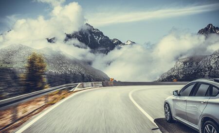 Highway among the mountain scenery. White car on a mountain road.の写真素材