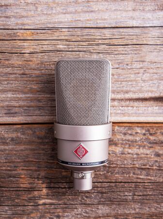 Large diaphragm condenser studio microphone Neumann tlm 103 on a wooden background.のeditorial素材