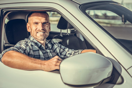 Attractive man driving a white car.