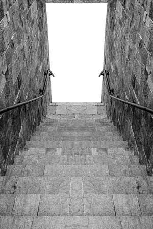 Steps of a stone staircase leading down with an isolated exit.の写真素材