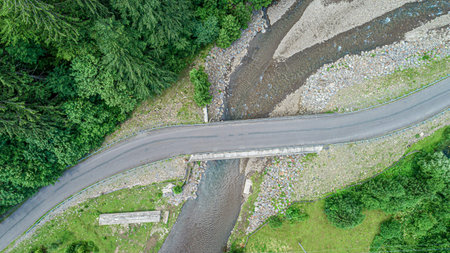 Automobile bridge over the river on the background of the forest in the mountains.